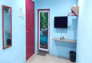 Pokój z czerwonymi drzwiami i telewizorem na ścianie w obiekcie OYO 90937 Tanjak Hotel w mieście Alor Setar