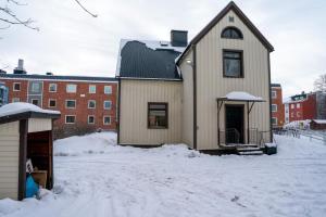 une maison dans la neige devant un bâtiment dans l'établissement Guestly Homes - Central Charm, à Boden
