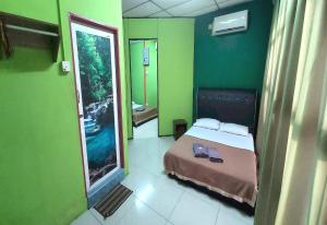 a bedroom with a bed and a large mirror at OYO 90937 Tanjak Hotel in Alor Setar