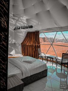 a bedroom with a bed and a view of the desert at RUM YANAL CAMP in Wadi Rum