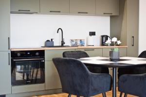 a kitchen with a table and chairs and a kitchen with a stove at Apartamenty LAGOM in Siedlce