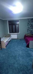 a room with two beds and a flat screen tv at Emir guest house in Batken