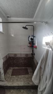 een badkamer met een douche en een glazen deur bij Emir guest house in Batken