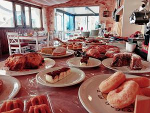 a table full of different types of pastries on plates at Villa Laura Apartment in Giardini Naxos