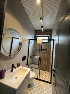 een badkamer met een toilet, een wastafel en een douche bij Azur Hotel in Cıralı