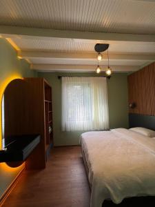 een slaapkamer met een groot bed en een raam bij Azur Hotel in Cıralı