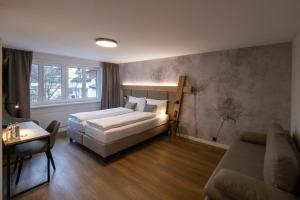 a bedroom with a bed and a couch and a table at Hotel Adler in Stein am Rhein