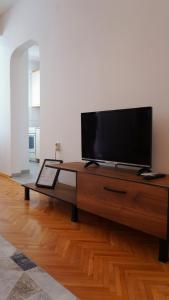 een flatscreen-tv op een houten tafel bij Lina's Apartment in Skopje