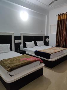 2 Betten in einem Zimmer mit 2 Betten sidx sidx sidx sidx in der Unterkunft Hotel Parbhat Palace in Katra
