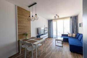 a living room with a blue couch and a table at ELINOR Apartments - B25 in St. St. Constantine and Helena