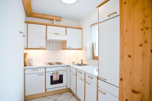 a kitchen with white cabinets and a sink at Appartement Comfort in Gröbming