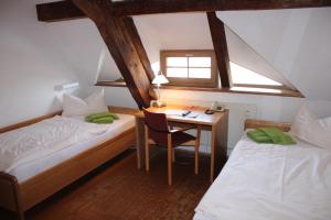 a room with two beds and a desk with a table at Gästehäuser St. Marienthal in Marienthal