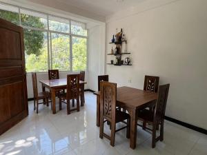a dining room with a table and chairs and a window at Kai Kazee Ella in Ella