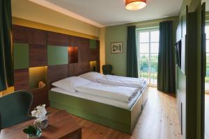 een slaapkamer met een groot bed en een tafel bij Hotel Agnesen-Hof in Barweiler