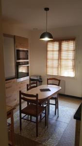uma cozinha com mesa e cadeiras num quarto em La Gloriette des Eglantines em Saint-Gervais-la-Forêt