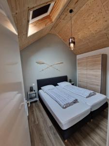 een slaapkamer met een groot bed en een houten plafond bij Zoetenaar Zoutelande in Zoutelande