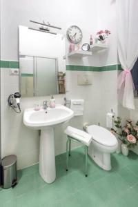 a white bathroom with a sink and a toilet at Casa Vacanze TaorminaCentre Guest house in Taormina