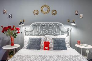 a white bed with a red teddy bear sitting on it at Casa Vacanze TaorminaCentre Guest house in Taormina