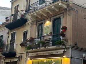 a building with balconies and windows with flowers on it at Casa Vacanze TaorminaCentre Guest house in Taormina