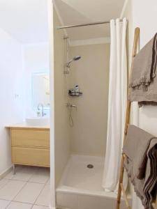 a white bathroom with a shower and a sink at T1 rénové à Nîmes in Nîmes
