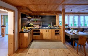 uma cozinha com armários de madeira e uma mesa num quarto em Blumbauernhof em Gutach
