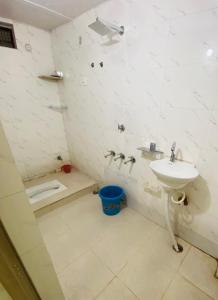 a white bathroom with a sink and a shower at Nirupam Sadan HomeStay in Vrindāvan