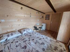a bedroom with a bed and a table in it at Glamping Laze in Gorenja Vas