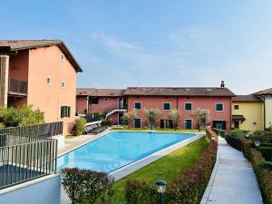 a swimming pool in a yard next to a building at Apartment Perlago in Costermano sul Garda