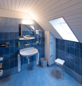 Baño azul con lavabo y aseo en Hotel Adler, en Stein am Rhein