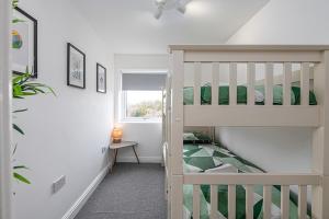 a small room with a bunk bed and a staircase at NR RHOSNEIGR-3 BED-STYLISH-RE-FURBISHED HOLIDAY HOME in Rhosneigr