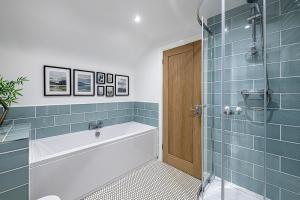 bagno con vasca e doccia con piastrelle blu di 3 BED-EN-SUITE-PRIVATE-PARKING- Near RHOSNEIGR a Rhosneigr Altre 21 foto