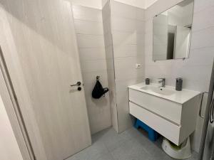 a white bathroom with a sink and a mirror at Apartment Sant'Antonio in Bari
