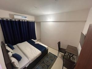 a bedroom with a bed and a desk and a table at Hotel Shree Prabhu in Vovale