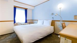 敦賀市にある東横INN敦賀駅前の白いベッドと窓が備わるホテルルームです。
