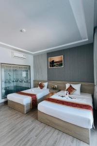 2 Betten in einem Hotelzimmer mit 2 Schlafzimmern in der Unterkunft Khoa Hotel Phan Thiết in Ấp Bình Hưng