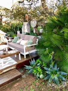 a patio with a couch and some plants at Glamping - La Casa del Piano in Chiclana de la Frontera