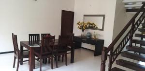 a dining room with a table and chairs and stairs at Shiraz villa in Chennai