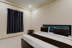 a bedroom with a large bed and a window at FabHotel JP International in Lucknow +23 photos