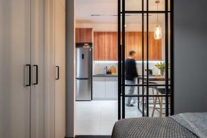Stylish & Modern Apartment I Blueloft 48 في طشقند: مطبخ فيه ثلاجة ورجل واقف في المطبخ