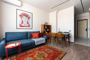 タシュケントにあるStylish & Modern Apartment I Blueloft 48のリビングルーム(青いソファ、テーブル付)