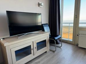 a flat screen tv sitting on top of a entertainment center at Luxe seaview appartment in Blankenberge