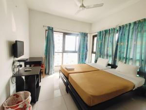 een slaapkamer met 2 bedden, een bureau en een televisie bij Private room in Blueridge in Hinjewadi