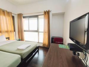 a bedroom with a bed and a flat screen tv at Private room in Blueridge in Hinjewadi