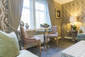 a room with a table and two chairs and a window at Town and Country Charleston Apartments in Aberdeen