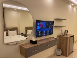 1 dormitorio con cama y espejo grande en Aster Hotel Aqaba, en Áqaba