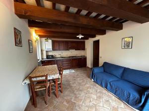 sala de estar con sofá azul y mesa en Il Casaletto Visso, en Visso