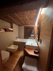 阿拉尼亞瓦爾塞西亞的住宿－Cozy 500 Years Old Walser Home，浴室配有盥洗盆、卫生间和浴缸。