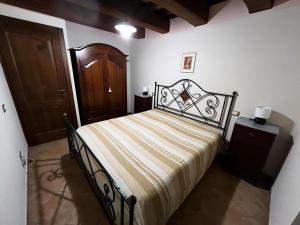 1 dormitorio con 1 cama grande y puerta de madera en Il Casaletto Visso, en Visso