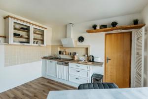 uma cozinha com armários brancos e uma bancada em Happy Place mit Sauna & Jacuzzi em Plettenberg