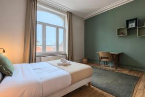 een slaapkamer met een bed, een bureau en een raam bij 2 bedroom apartment with terrace, near Lille in Lille